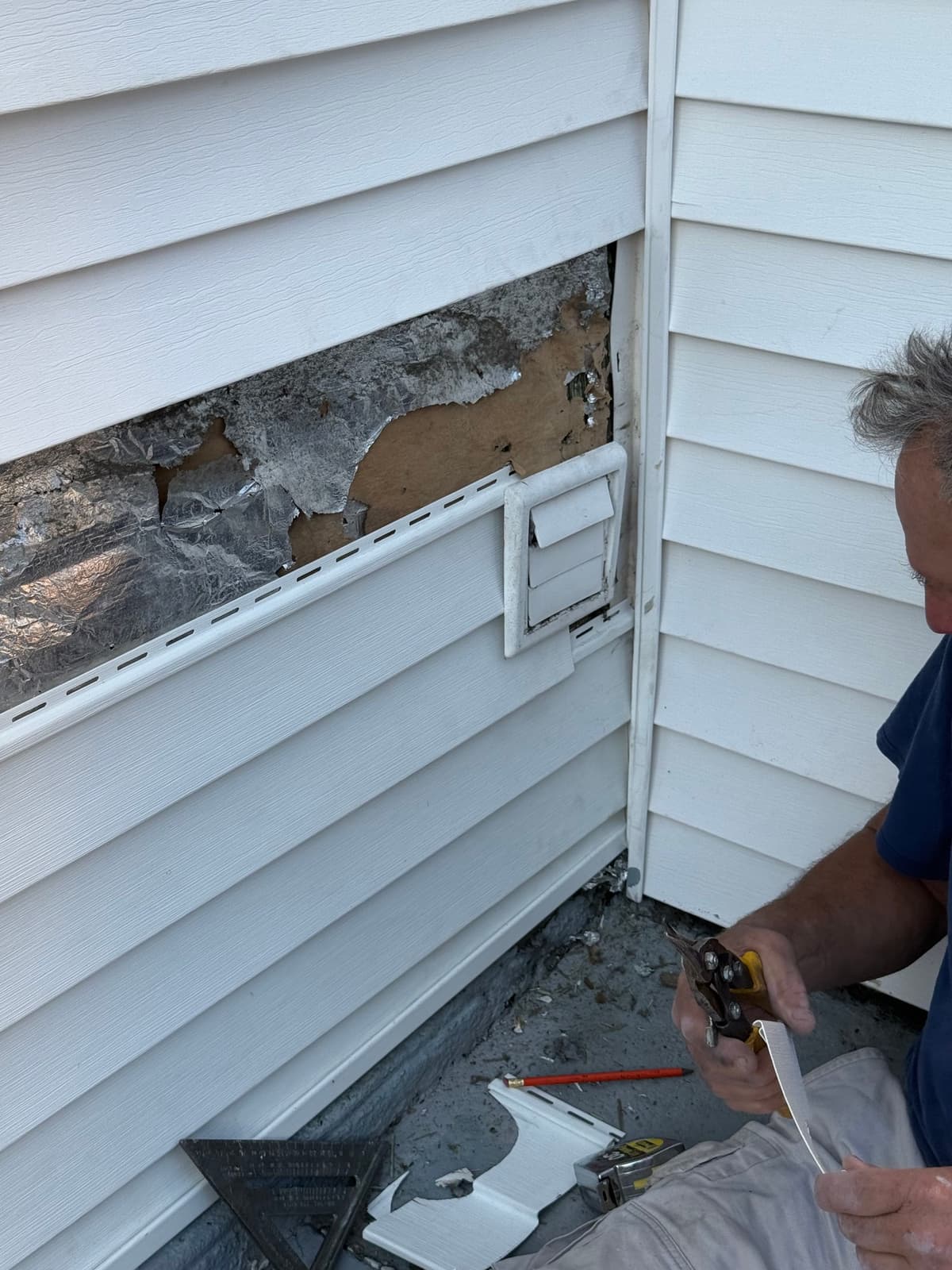 Custom-fitting a new piece of trim around the vent so the repair reads as original, not patched in.